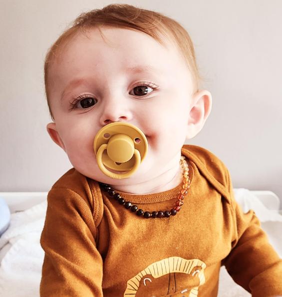 bébé avec collier d'ambre cognac