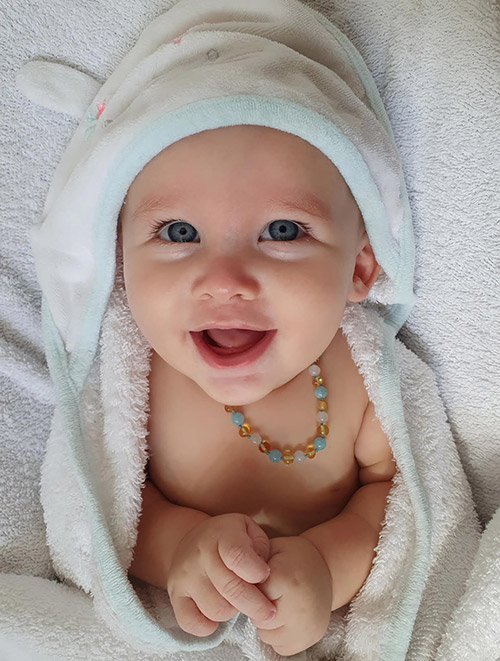 bébé avec collier ambre et aigue-marine